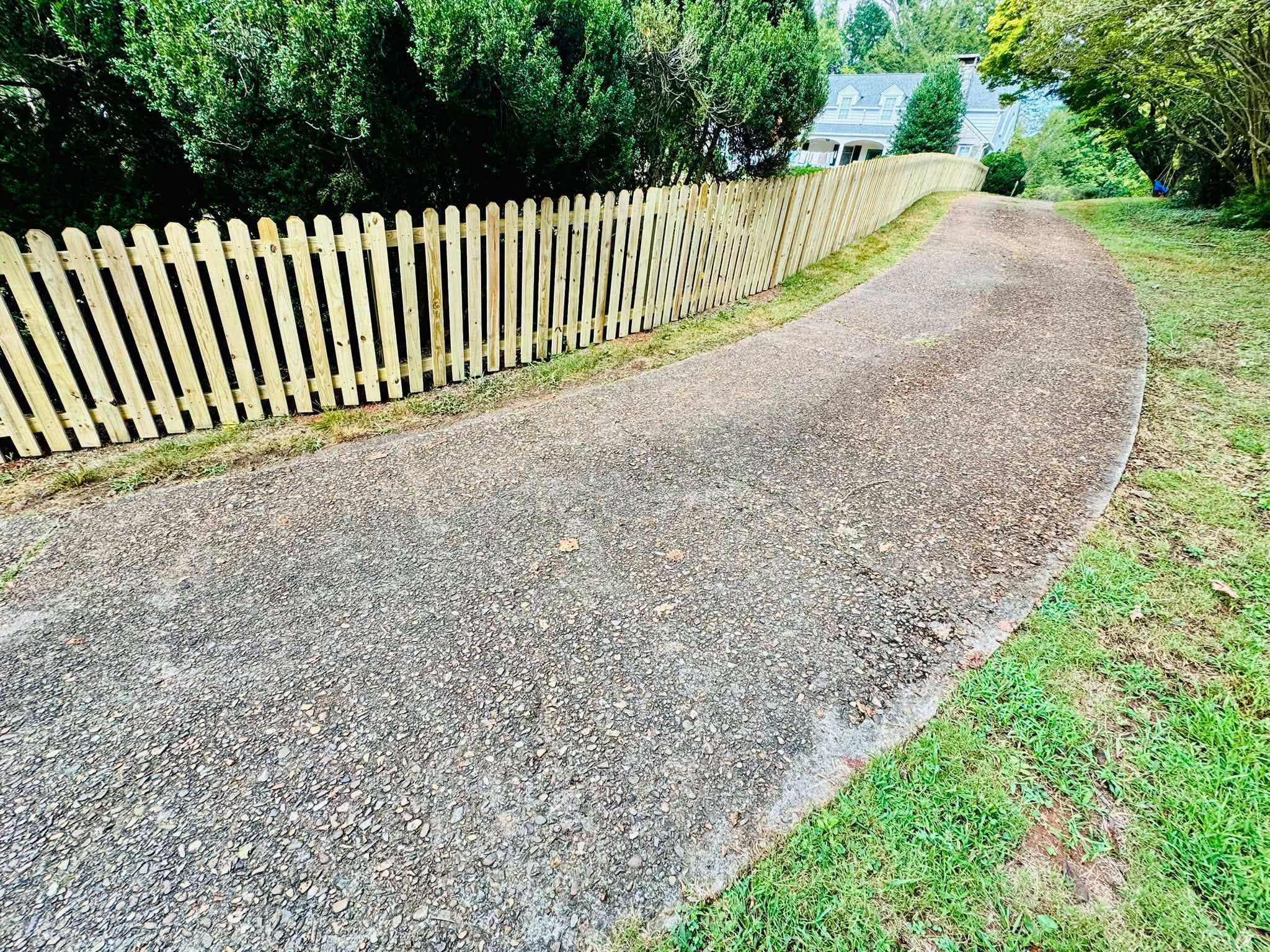 New wood picket fence along a driveway in Athens, TN, built by Athens Fence Company