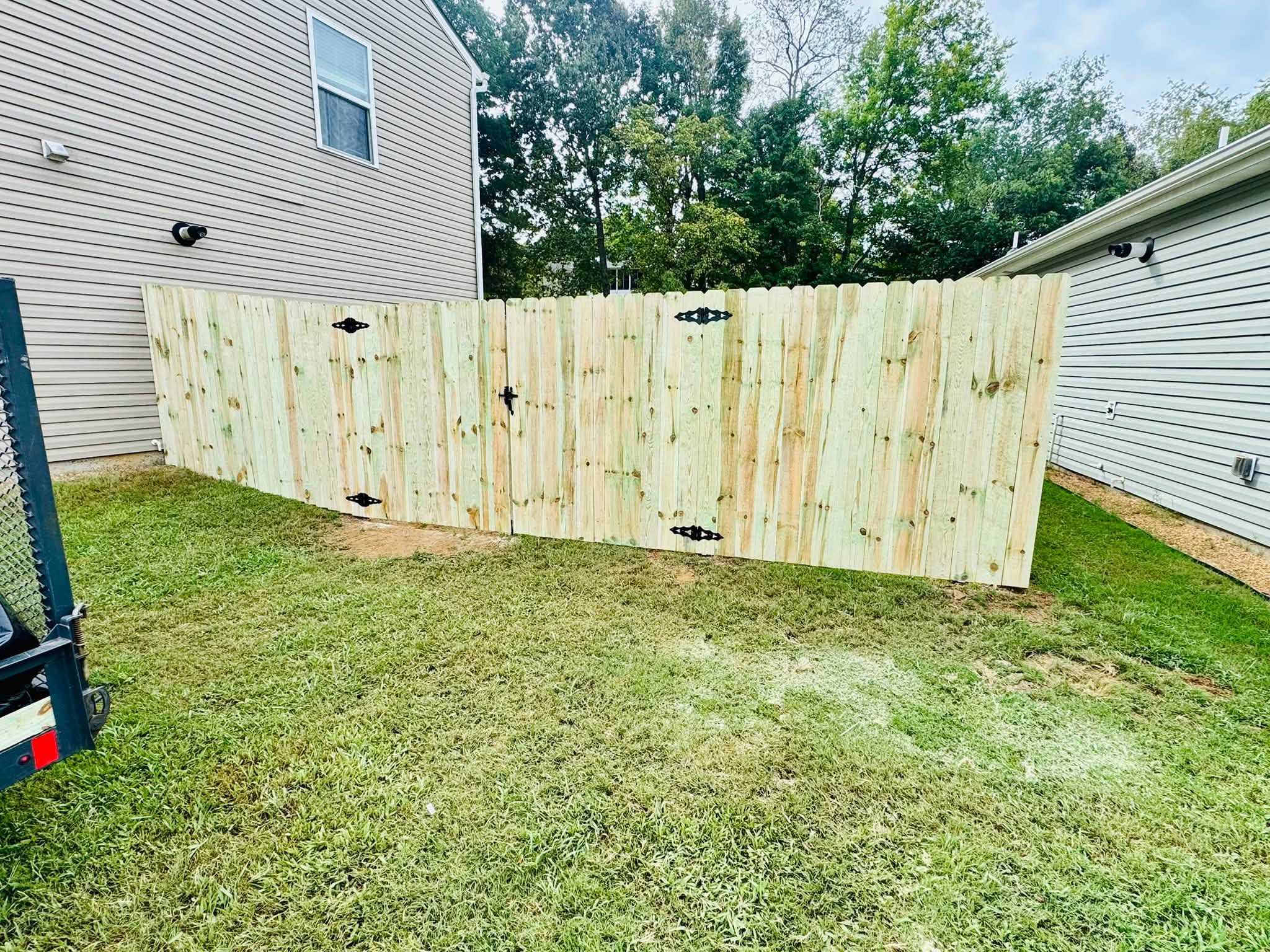 New wood privacy fence with gates built by Athens Fence Company between two homes in Athens, TN